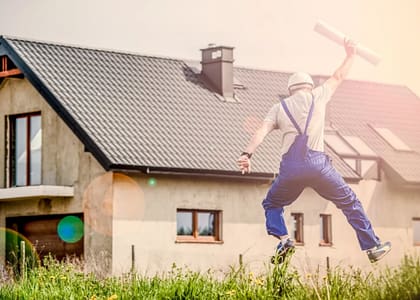 man jumping in front of house